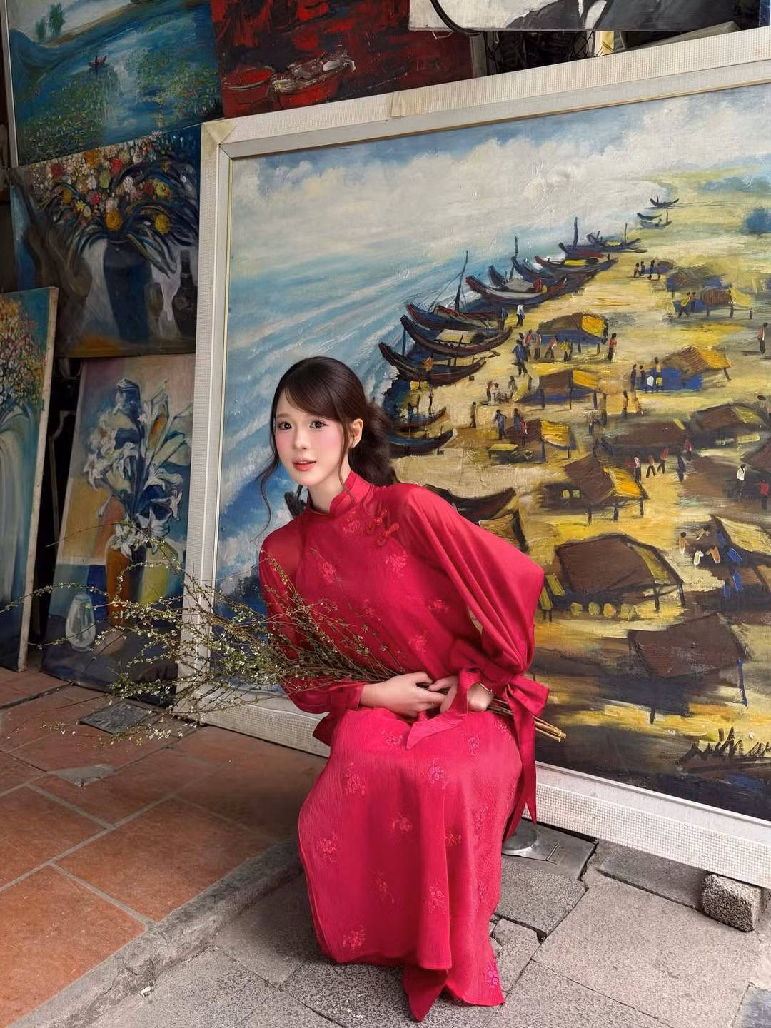 Sự kết hợp giữa tà áo dài đỏ nổi bật cùng những cành tuyết mai trắng muốt - loài hoa đặc trưng của mùa xuân miền Bắc - đã tạo nên một tổng thể vô cùng hài hòa và đậm chất thơ. (Ảnh: IGNV)