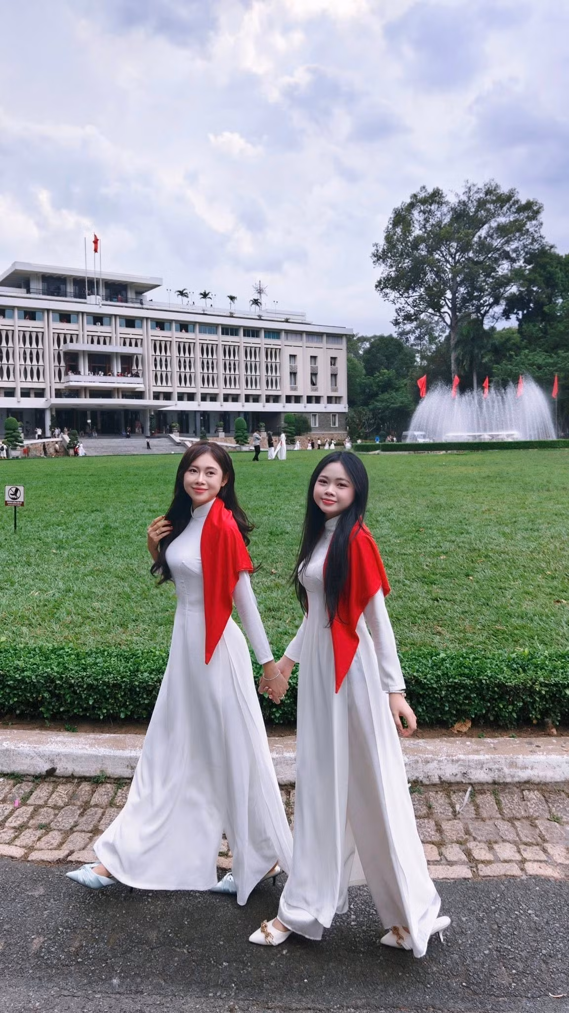 Chiếc khăn quàng đỏ thắm điểm xuyết trên vai không chỉ tạo điểm nhấn nổi bật mà còn gợi lên cảm giác tự hào dân tộc, khiến tổng thể bộ ảnh trở nên ý nghĩa hơn. (Ảnh: FBNV)