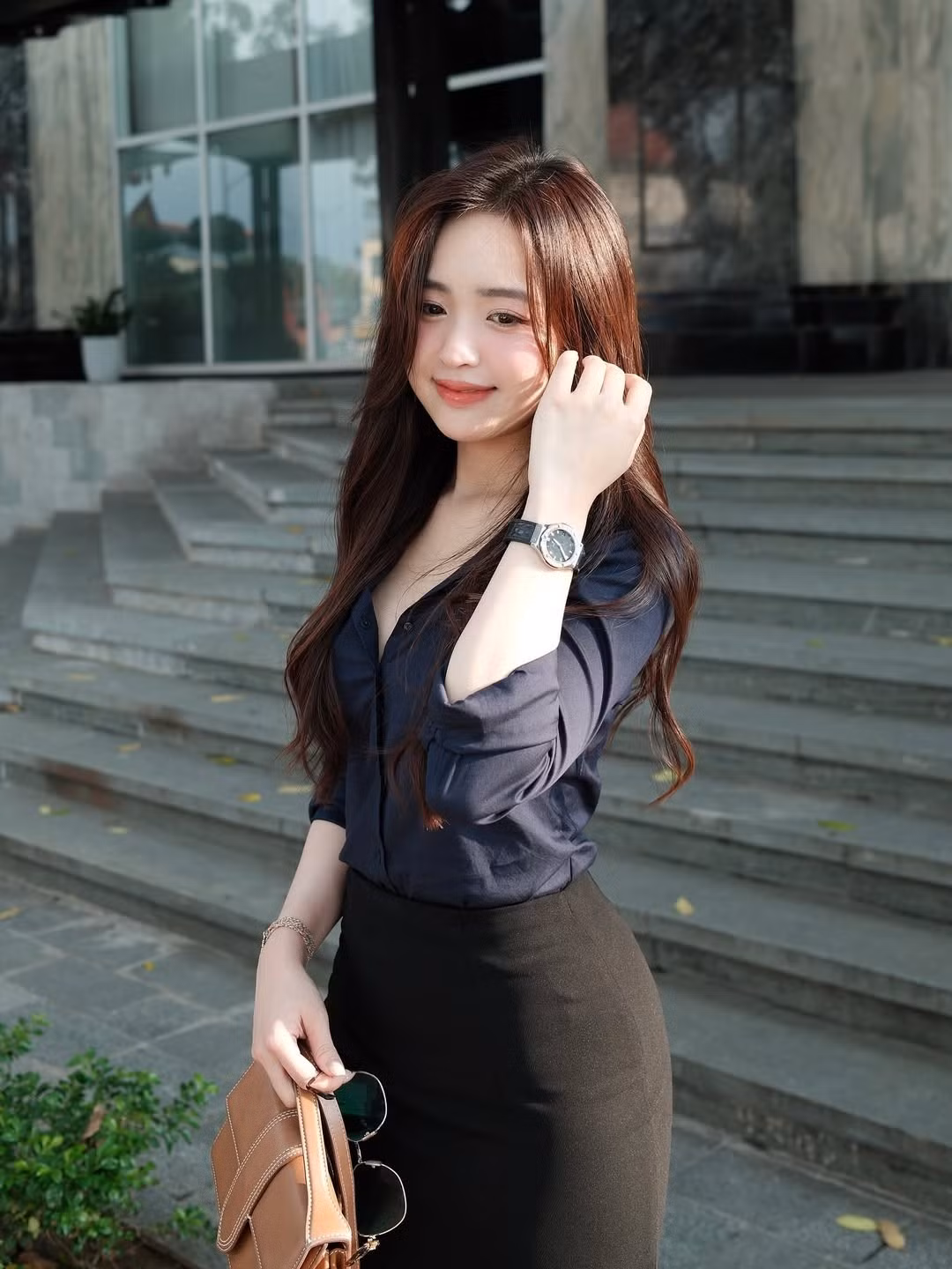 Cô nàng diện một chiếc áo sơ mi màu xanh navy phối cùng chân váy bút chì màu đen, tạo nên một tổng thể vừa chuyên nghiệp, vừa tôn lên vóc dáng mảnh mai, quyến rũ. (Ảnh: IGNV)