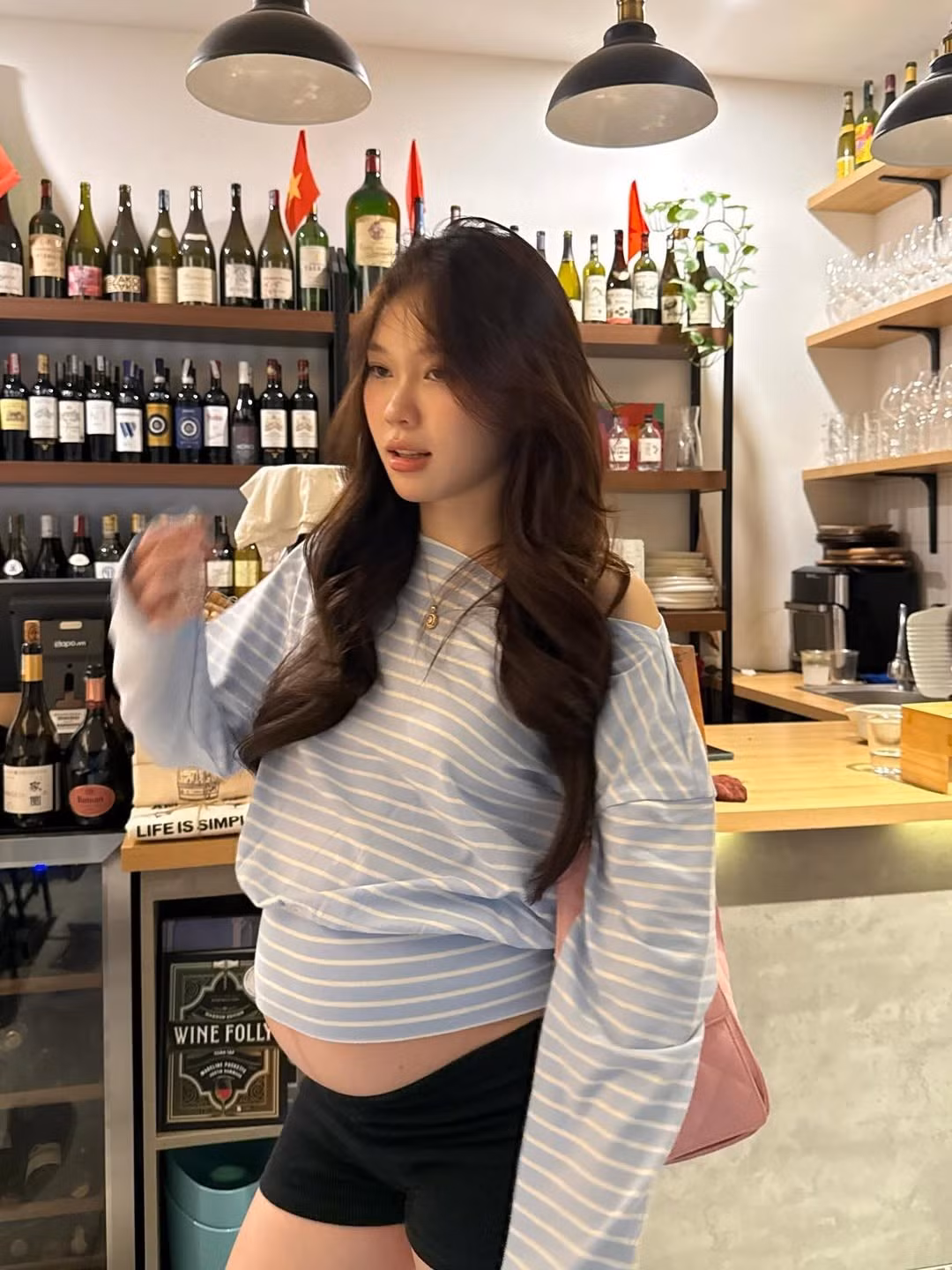 Trong một bộ ảnh, Ly Phạm thể hiện sự phá cách với chiếc áo sweater kẻ sọc xanh trắng trễ vai, quần short đen và giày thể thao. (Ảnh: IGNV)