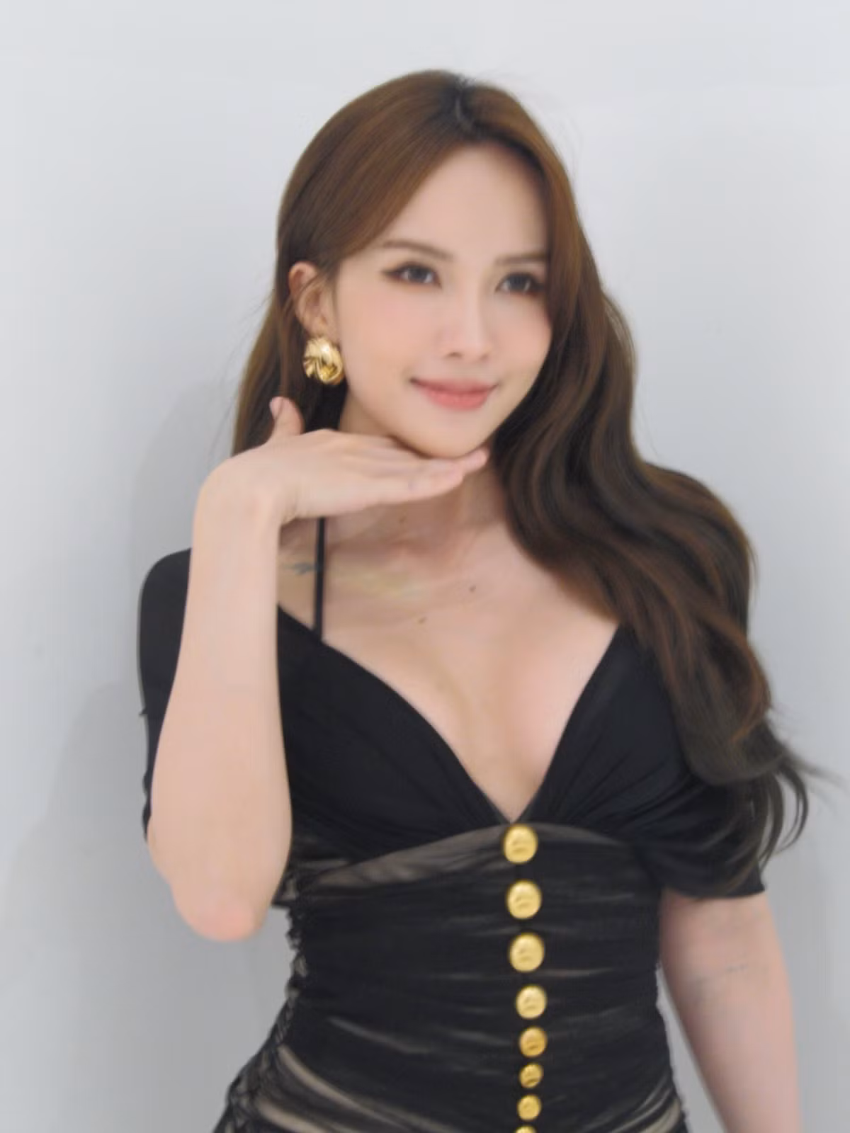 Trong bộ ảnh, Thiều Bảo Trâm khoác lên mình chiếc váy ôm sát màu đen, nổi bật với những đường cắt xẻ tinh tế cùng hàng cúc vàng chạy dọc thân váy. (Ảnh: FBNV)