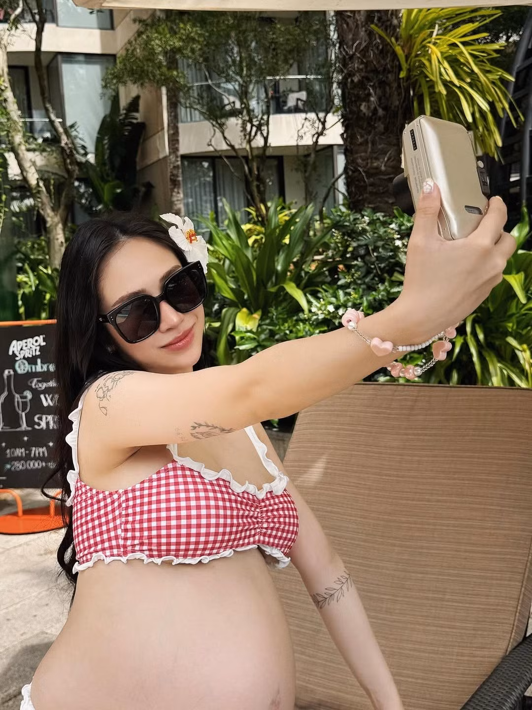 Cô không ngần ngại tạo dáng bên hồ bơi và khu vực quầy bar, thể hiện sự thoải mái và tận hưởng những khoảnh khắc cuối cùng của hành trình mang bầu.