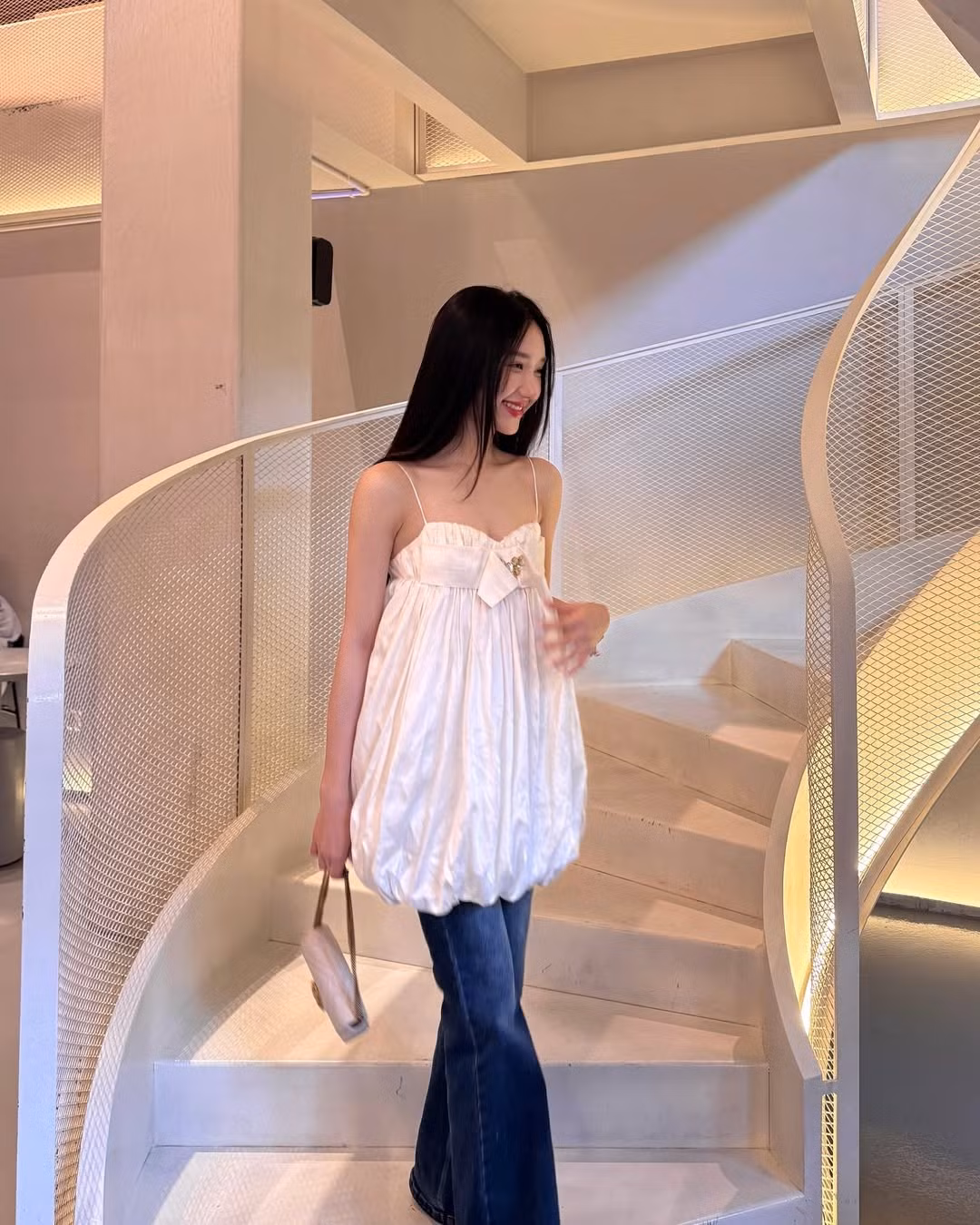 Trong bộ trang phục gồm áo hai dây dáng babydoll phối cùng quần jeans ống loe, Mina như hóa thân thành “nàng thơ” đậm chất Hàn, ngọt ngào và cuốn hút.