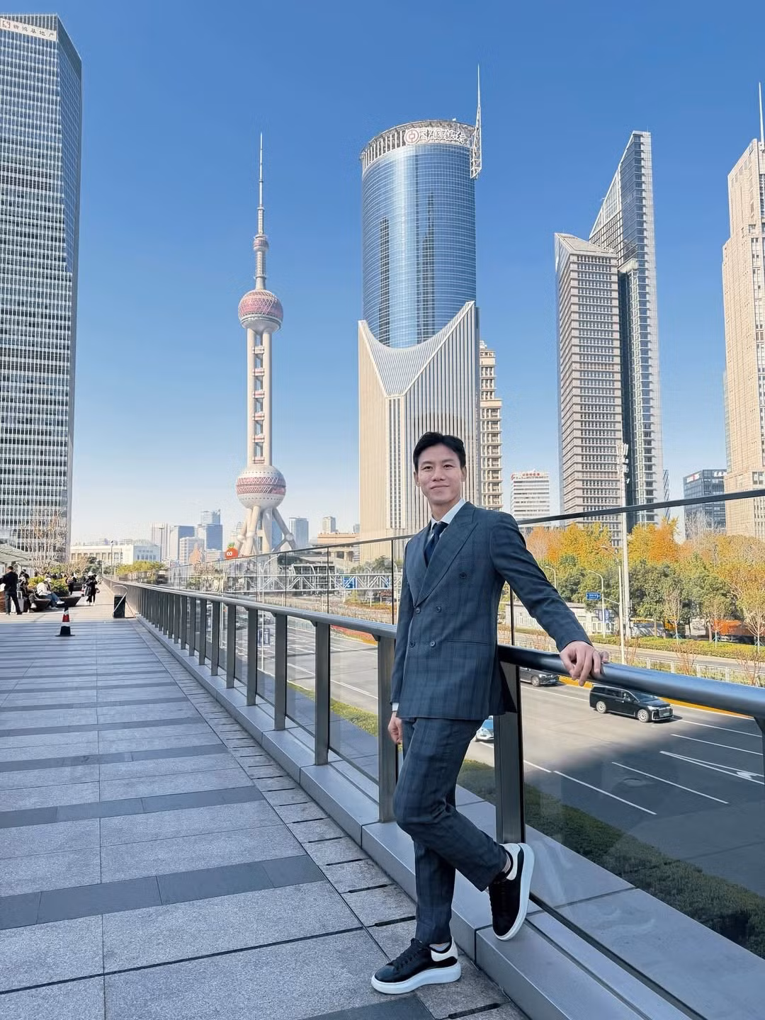 Cặp đôi xuất hiện tại khu Phố Đông, nơi có Tháp truyền hình Minh Châu Phương Đông, Tháp Thượng Hải và các tòa nhà chọc trời. Quế Ngọc Hải trong bộ suit xám kẻ caro lịch thiệp, khoác áo dạ đen, sánh bước cùng vợ. (Ảnh: IGNV)