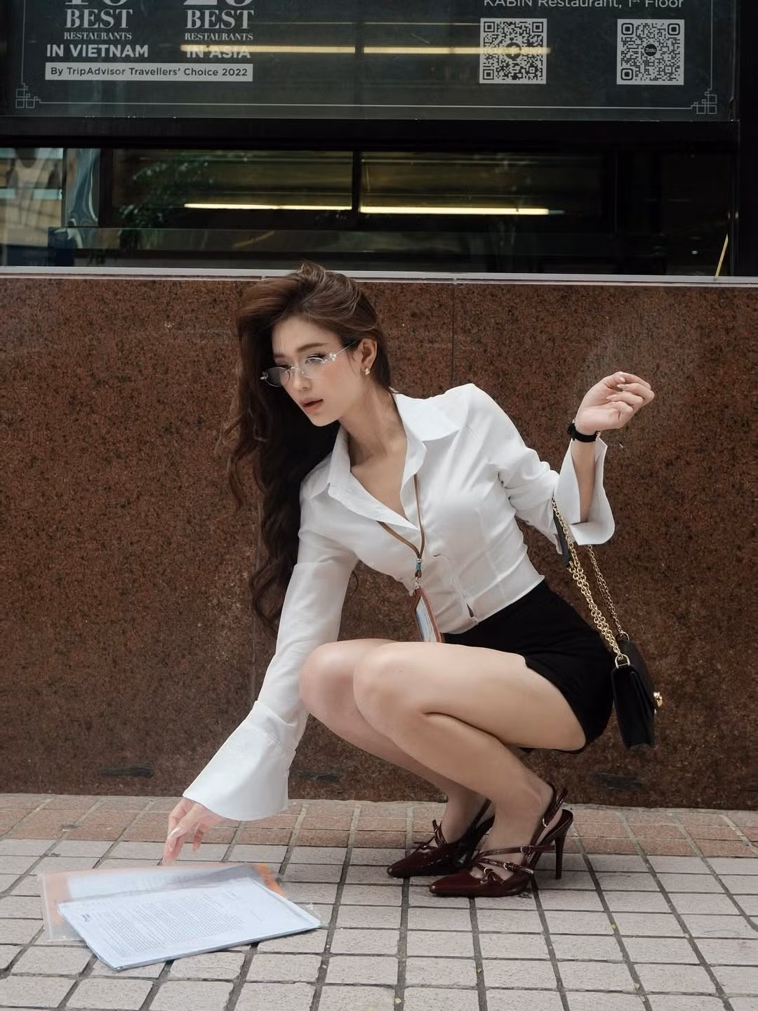 Điểm nhấn của bộ trang phục nằm ở phụ kiện đi kèm: chiếc kính gọng mảnh làm tôn lên đường nét gương mặt thanh tú, kết hợp cùng mái tóc xoăn bồng bềnh tự nhiên và thần thái lạnh lùng, cuốn hút. (Ảnh: IGNV)