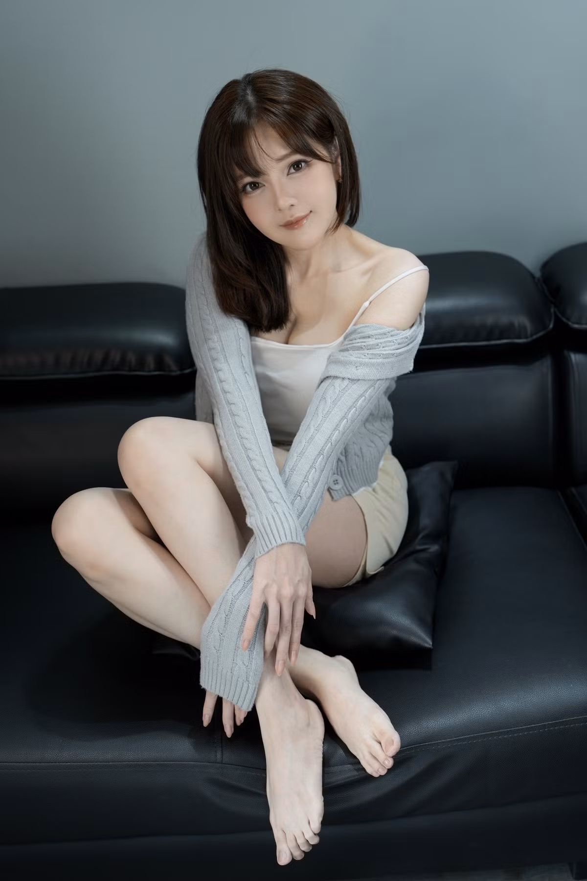 Cô nàng diện một chiếc áo hai dây trắng đơn giản kết hợp với quần short thể thao màu be nhạt và khoác ngoài một chiếc áo cardigan dệt kim mỏng màu xám. (Ảnh: FBNV)