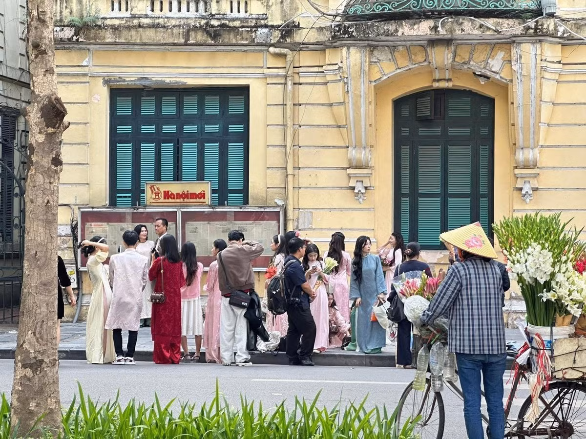 Bên cạnh bờ hồ, các địa điểm lân cận cũng thu hút đông đảo người dân như trước tòa soạn báo Hà Nội Mới, với mảng tường vàng đặc trưng và bảng tin cổ điển, đây là góc chụp ảnh "quốc dân" chưa bao giờ hết hot.