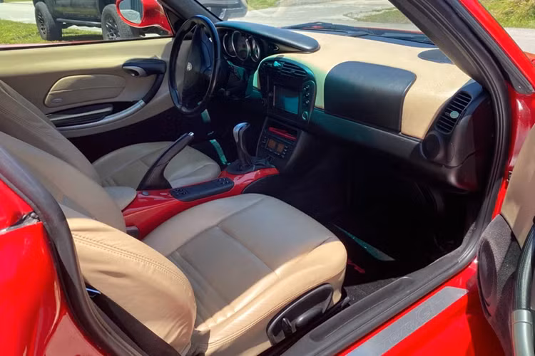 Tổng quan nội thất của chiếc Porsche Boxster này vẫn được giữ nguyên với tông màu nâu/đen. Khu vực tựa tay trung tâm cũng được sơn lại màu đỏ giống ngoại thất.