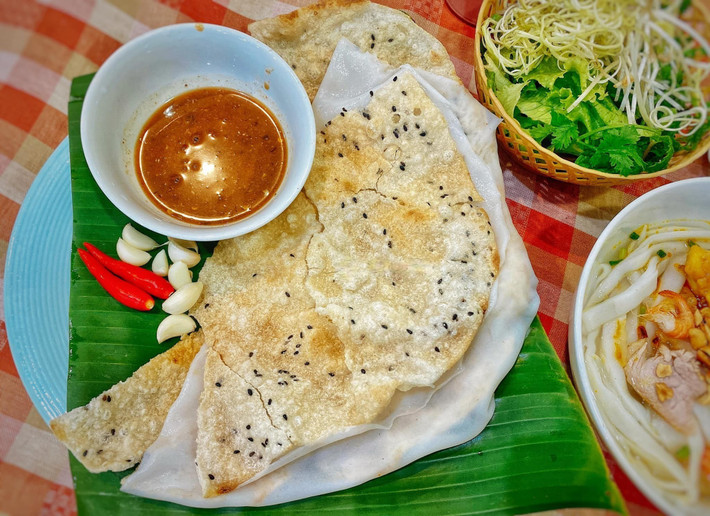 Cái thú vị nằm ở sự đối lập của hai lớp bánh: một giòn tan, một dai mềm, hòa quyện cùng mắm nêm dậy vị khiến ai ăn rồi cũng khó lòng quên được. Đặc biệt, món ăn này không cần cầu kỳ trong cách trình bày, càng mộc mạc càng ngon. Ảnh Vietnamnet