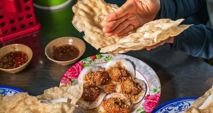 Khi ăn, thực khách phải tự “đập” bánh bằng tay cho vỡ ra từng miếng nhỏ, rồi chấm vào bát mắm nêm được pha chế đậm đà, thơm nồng với tỏi, ớt và chút chanh hoặc dứa băm nhuyễn. Ảnh Internet