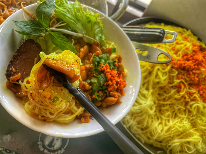 Kết thúc foodtour bằng một phần bún lòng xào nghệ – món ăn dân dã nhưng hút khách không kém. Bún tươi xào cùng lòng bò, nghệ tươi và lá hẹ, mang sắc vàng rực rỡ, thơm nhẹ, cay cay và không hề tanh. Mỗi đũa bún đều đậm đà và hài hòa từ hương đến vị. Ảnh VinWonder