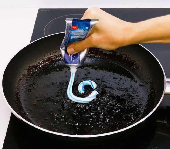 Bôi kem đánh răng lên phần đáy cháy đen, để trong 10–15 phút. Sau đó dùng bàn chải mềm hoặc miếng rửa chén chà nhẹ. Cách này thích hợp với vết cháy nhẹ hoặc nồi inox xỉn màu. Ảnh Bachhoaxanh