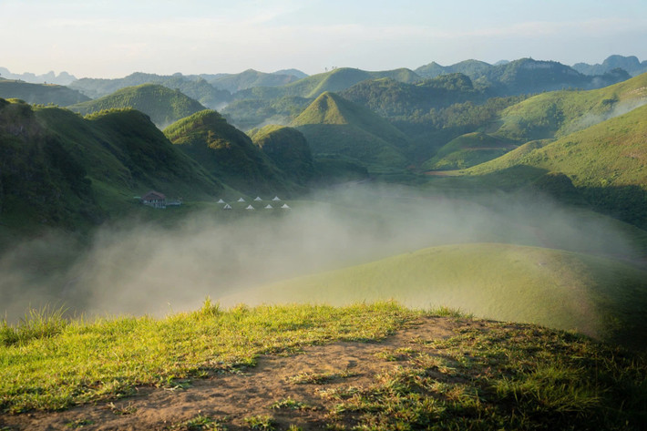 Cung đường đến đây tuy có phần xa xôi, khúc khuỷu, nhưng bù lại là hành trình mở ra vô vàn khung cảnh đắt giá, đặc biệt là những sườn núi trùng điệp, ruộng bậc thang xanh mướt và bản làng yên bình nằm nép mình dưới chân núi. Ảnh Thế Kiệt