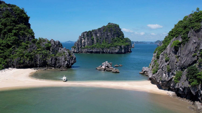 Thời điểm đẹp nhất để ghé thăm Cát Oăn là từ tháng 4 đến tháng 9, khi thời tiết khô ráo, nước biển trong xanh và ánh nắng chan hòa. Vào những ngày nắng đẹp, từ trên cao nhìn xuống, bãi biển hiện lên với gam màu chuyển dần từ xanh lam sang ngọc bích, kết hợp cùng bờ cát trắng mịn, tạo nên khung cảnh không khác gì tranh vẽ. Ảnh Nguyễn Hùng