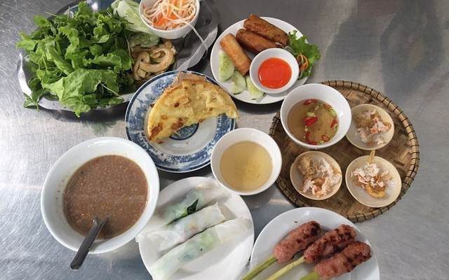 Nằm trong danh sách những món đặc trưng không thể thiếu là bánh khoái Hạnh tại đường Phó Đức Chính. Khác với bánh xèo miền Nam, bánh khoái Huế dày, giòn rụm, được chiên cùng tôm, thịt, trứng và giá. Giá trung bình khoảng 25.000 – 35.000 đồng/cái. Nhưng điểm khiến du khách nhớ mãi chính là chén nước lèo sền sệt, được pha chế từ gan heo, đậu phộng rang và tương mè – hương vị béo bùi rất riêng mà không nơi nào có được. Ảnh Foody