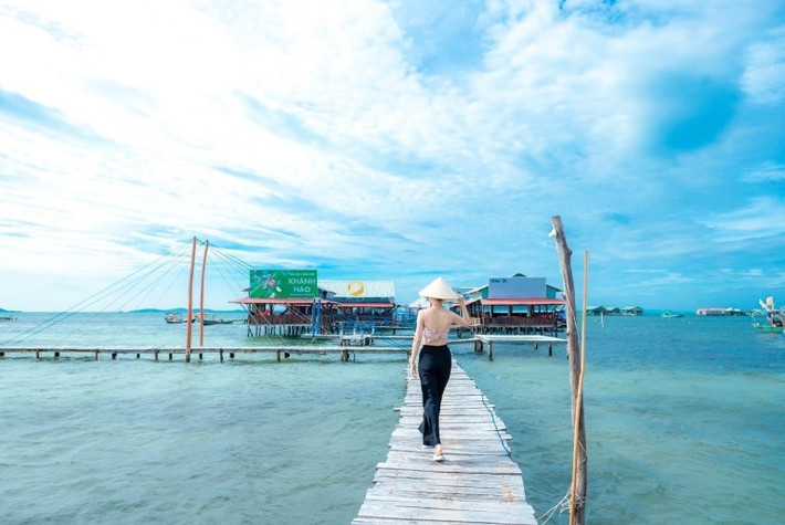 Rạch Vẹm không phải là nơi ồn ào, sôi động với các dịch vụ du lịch hiện đại. Thay vào đó, nơi đây hiện lên như một bức tranh làng chài mộc mạc với những căn nhà bè nối nhau trên mặt nước, cầu gỗ bắc ra biển và tiếng sóng rì rào vỗ về quanh năm. Khi đặt chân đến đây, du khách như được tách biệt hoàn toàn khỏi nhịp sống vội vã để đắm mình trong không gian bình yên, thư thái. Ảnh Thu Hoài