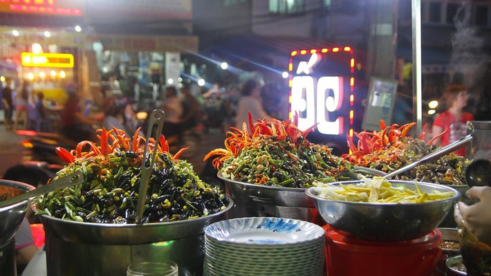 Nếu là tín đồ món ốc, du khách nên tìm đến quán Ốc Hà – địa chỉ có tuổi đời hơn 35 năm tại chợ Cồn. Ngay từ xa, mùi thơm từ ba nồi ốc nghi ngút khói đã lan tỏa, quyện giữa lá chanh, gừng, sả và ớt tươi. Quán có các món ốc hút, ốc đá, ốc len xào dừa và ốc bươu trộn, món nào cũng nóng hổi, thấm đẫm gia vị, ăn kèm nước chấm cay nồng rất đúng gu miền Trung. Ảnh Foody