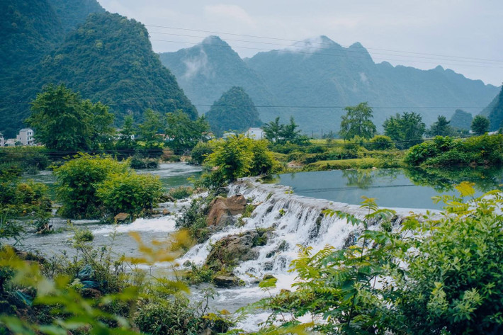 Không chỉ sở hữu cảnh sắc hút hồn, Cao Bằng còn là nơi để du khách cảm nhận trọn vẹn nhịp sống chậm rãi và giản dị. Những bản làng người Tày, Nùng nằm yên bình dưới chân núi, những mái nhà sàn lợp ngói âm dương phủ màu thời gian. Buổi sáng mù sương, tiếng gà gáy vọng từ xa, khói lam chiều bảng lảng giữa rừng khiến lòng người lữ hành bỗng dịu lại. Ảnh Bùi Ngọc Lâm