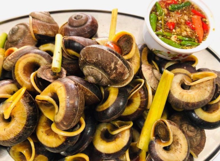 Ốc đá là một loại ốc được bắt từ sâu trong mỏm núi đá. Sau khi làm sạch thì ốc được luộc lên với sả và gừng, chấm với nước mắm gừng ớt, lá chanh. Phần thịt ốc dày, chắc, thơm ngon kết hợp với nước mắm khiến món ăn càng thêm phần cuốn hút. Ảnh amthuctaybac
