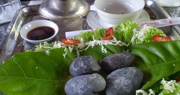 Sỏi được chọn kỹ, rửa sạch và nung trên bếp củi cho đến khi nóng đỏ, sau đó được bày ra mâm hoặc khay lớn. Ảnh Mỹ Hân