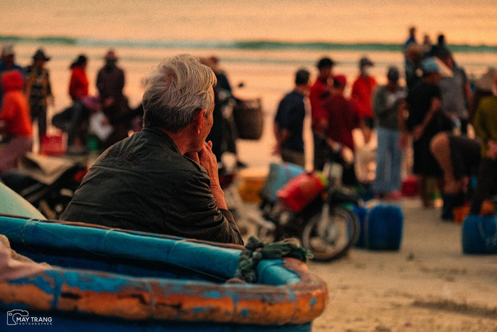 Ánh sáng dịu dàng của ngày mới làm nổi bật từng mái nhà, từng dãy lưới cá và gương mặt người dân tràn đầy sức sống. Ảnh Mây Trắng