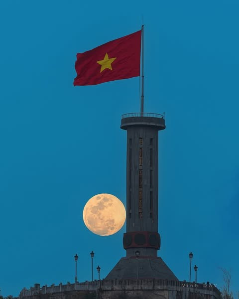 Một trong những khoảnh khắc ấn tượng nhất mà du khách có thể trải nghiệm khi đến Lũng Cú là cảnh Mặt Trăng dần dần hiện lên đúng trên đỉnh cột cờ, ngay lúc cờ đỏ sao vàng phấp phới trong làn gió mạnh. Ảnh Vinh Dav