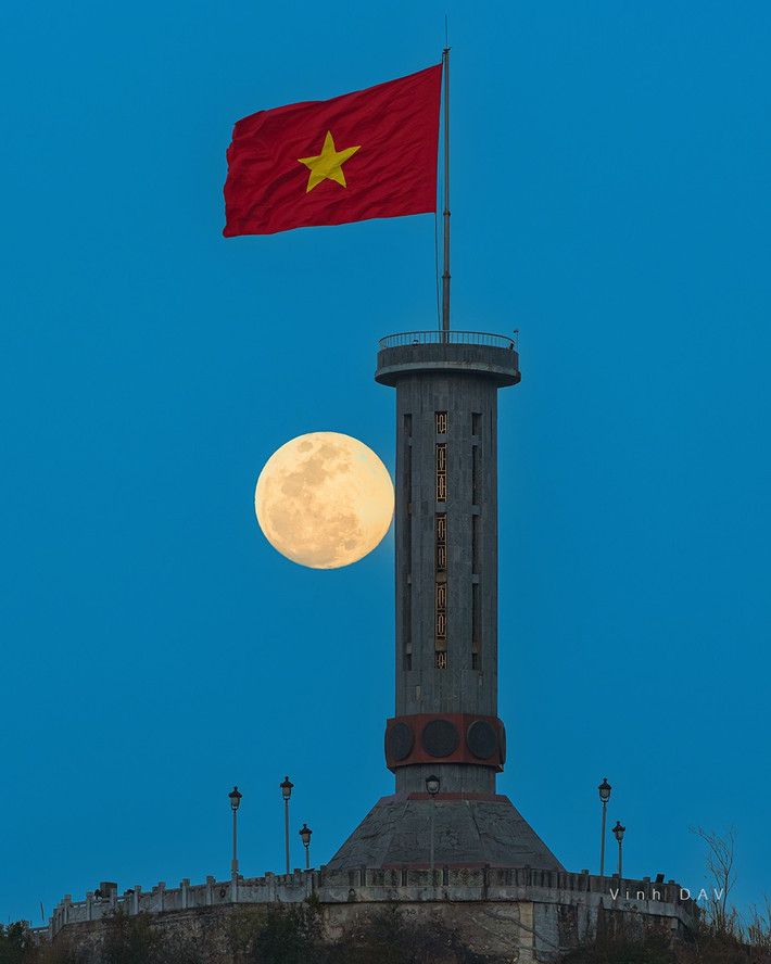 Bầu trời đêm miền biên ải trong xanh, ánh trăng tỏa sáng khắp không gian, chiếu rọi lên lá cờ đỏ sao vàng đang bay mạnh mẽ, tạo nên một hình ảnh tuyệt vời không thể diễn tả bằng lời. Ảnh Vinh Dav