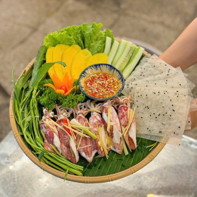 Theo tìm hiểu, mực hấp cuốn rau muống có nguồn gốc từ các vùng ven biển miền Trung như Tam Kỳ (Quảng Nam) và Đà Nẵng. Tại đây, người dân thường tận dụng rau muống biển trồng tại chỗ, mực tươi đánh bắt trong ngày, kết hợp cùng bánh tráng mè đen – loại bánh đặc trưng của miền Trung, tạo nên hương vị rất riêng biệt. Khi được ngâm mềm, bánh tráng trở nên dẻo dai, thơm bùi, làm tăng thêm sự tròn vị cho món cuốn. Ảnh Hà Nguyên