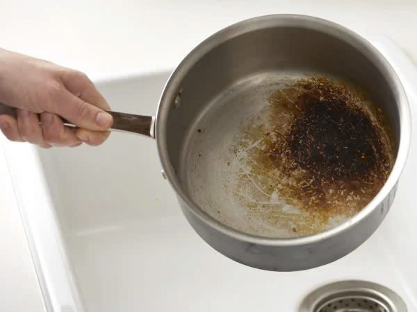 Đổ coca ngập phần đáy nồi, ngâm vài giờ hoặc để qua đêm. Sau đó chà nhẹ, các mảng cháy sẽ bong tróc mà không làm hỏng bề mặt nồi. Vừa nhanh gọn, vừa tiết kiệm. Ảnh Cleanipedia