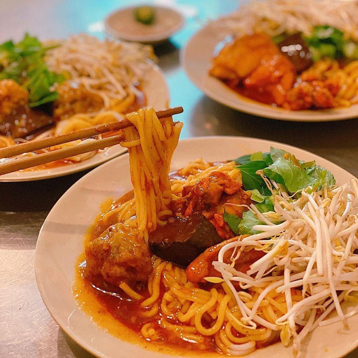 Một tô bánh tầm cay hoàn chỉnh sẽ có sợi bánh mềm, thấm đẫm nước cà ri béo cay, ăn kèm xíu mại, trứng non hoặc thịt gà, thêm ít rau sống thái nhỏ. Ảnh MIA