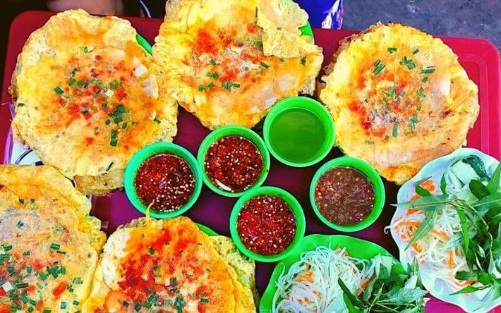 Nếu du khách muốn tìm món ăn vặt “đậm chất học trò” thì bánh ép chị Xí ở kiệt Nhật Lệ là địa chỉ không thể bỏ qua.Chỉ với 2.000 – 5.000 đồng/chiếc, du khách đã có ngay chiếc bánh ép nóng hổi, nhân thịt thơm lừng, ăn kèm nước mắm chua ngọt cay cay và đu đủ ngâm. Quán thường mở cửa vào buổi chiều, đông nghịt học sinh – sinh viên đến ăn và trò chuyện. Ảnh amthuc