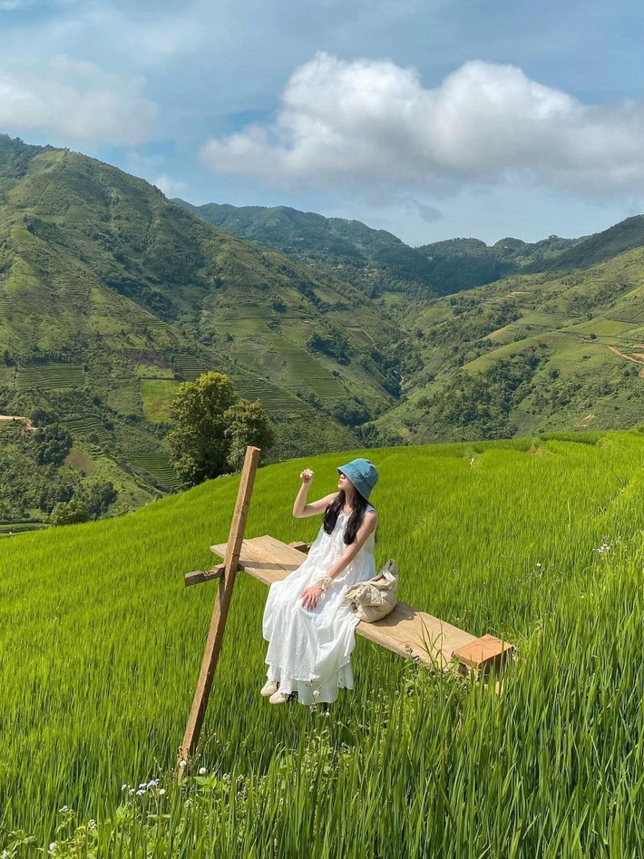 Mùa lúa xanh ở Xím Vàng không rực rỡ như mùa lúa chín, nhưng lại mang đến cảm giác trong lành, thanh sạch. Những thửa ruộng như từng lớp sóng lúa ôm lấy chân núi, xen kẽ là những lối mòn đất đỏ và con suối nhỏ róc rách chảy ngang bản. Ảnh Nguyễn Phương Thảo