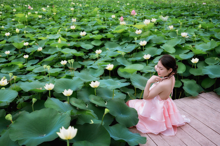 Với những ai yêu phong cách cổ truyền, diện yếm đào – đội nón lá là lựa chọn lý tưởng, vừa tôn lên vẻ mềm mại vừa nổi bật giữa nền sen xanh. Một kiểu khác không thể bỏ qua là chụp từ trên cao, gợi nét mong manh giữa biển lá sen mướt mát. Cuối cùng, hãy thử chụp cận mặt, lấy hoa làm điểm nhấn, để khơi gợi chiều sâu cảm xúc trong từng khung hình. Ảnh Gia Hân