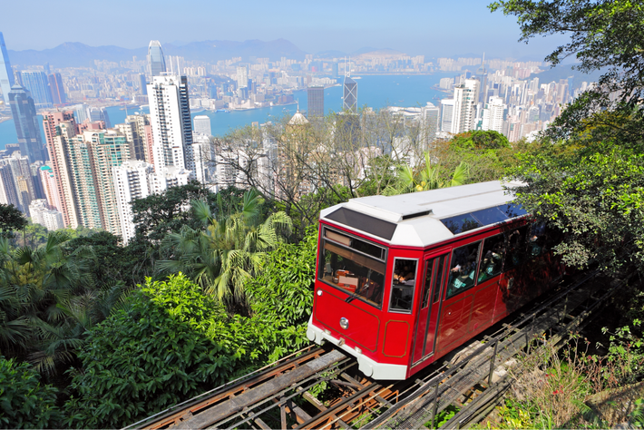 Chuyến tàu điện Peak Tram cổ nhất châu Á, với độ dốc tới 27 độ, đưa du khách băng qua rừng cây và những khúc cua ngoạn mục, mang lại cảm giác vừa phiêu lưu vừa lãng mạn. Ảnh Vietravel