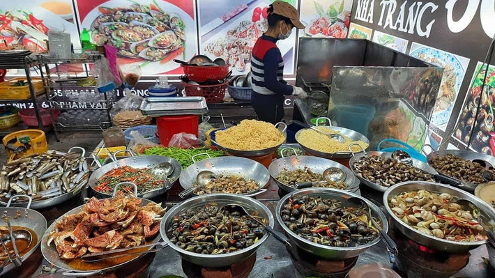 Đến Nha Trang mà không ăn ốc đêm thì quả là thiếu sót. Những hàng ốc vỉa hè trên đường Tháp Bà, Nguyễn Trường Tộ hay Hòn Chồng bày biện đơn giản nhưng luôn tấp nập thực khách. Ốc hấp sả, ốc nướng mỡ hành, sò điệp phô mai, càng ghẹ rang muối… tất cả đều tươi rói và đậm đà. Giá cả hợp túi tiền, chỉ từ 30.000 – 60.000 đồng/dĩa. Ảnh MIA