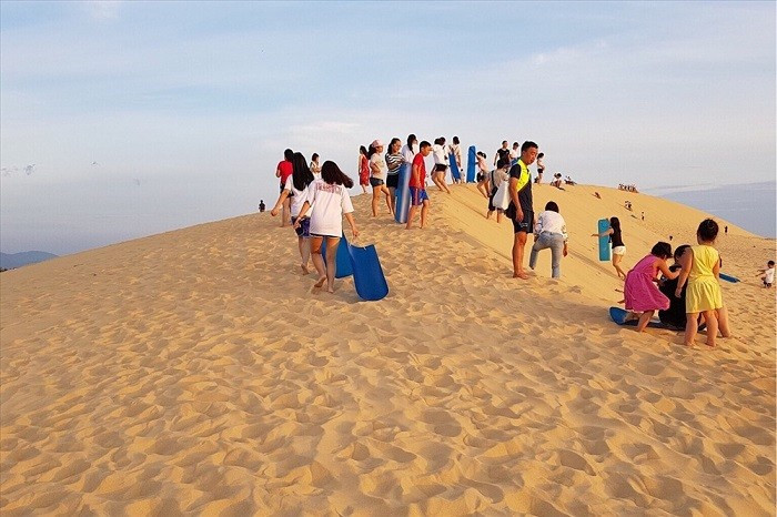 Điều thú vị là hiện tại, đồi Phú Quang chưa thu vé vào cửa, du khách được tham quan tự do. Một số người dân và doanh nghiệp địa phương đã chủ động cung cấp các dịch vụ trải nghiệm như trượt cát, xe địa hình, nước uống… để phục vụ du khách. Với bề mặt cát rộng, thoai thoải, đồi trở thành địa điểm lý tưởng cho trò chơi trượt cát – một hoạt động thú vị, thu hút cả người lớn lẫn trẻ em. Ảnh QuangBinh Travel