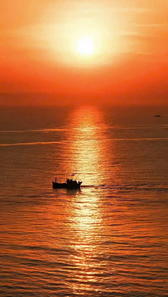 Mặt trời dần hiện lên giữa làn mây mỏng, nhuộm hồng cả mặt biển, ánh sáng phản chiếu lên những khối đá tạo nên một khung cảnh huyền ảo như tranh vẽ. Ảnh Kim Phương