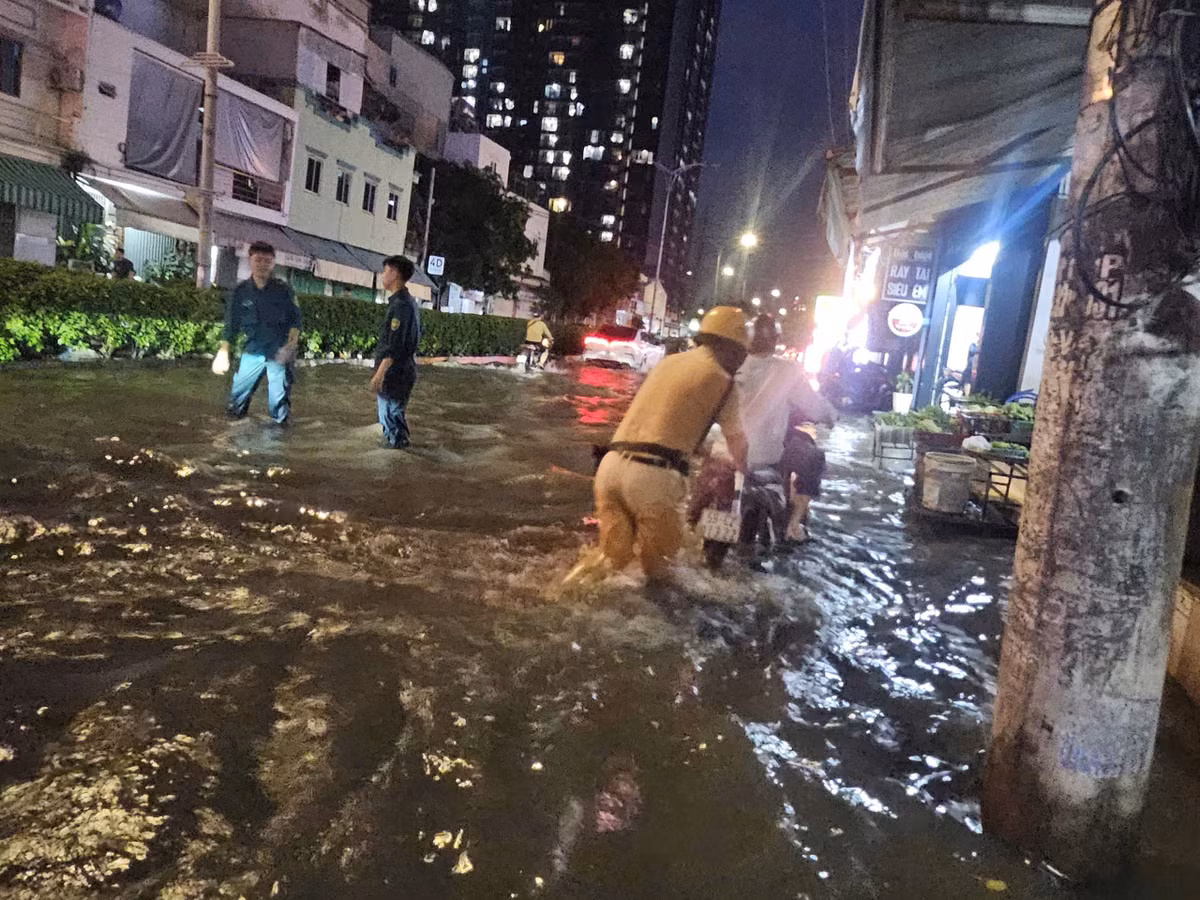 Tại giao lộ Huỳnh Tấn Phát - Phú Thuận (điểm ngập nặng ở TP HCM), CSGT Trạm Đa Phước (Phòng CSGT - PC08, Công an TP HCM) phối hợp nhiều đơn vị địa phương đã có mặt từ chiều đến tối để hỗ trợ người dân.