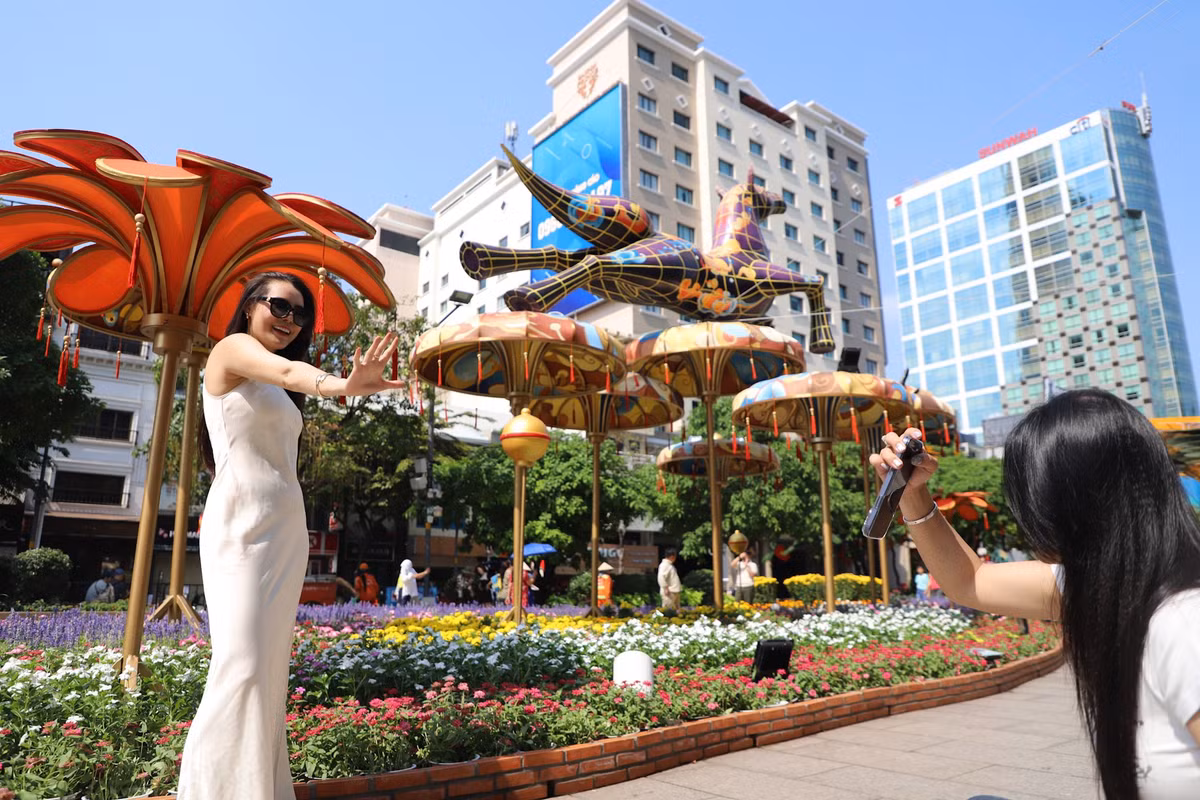 Thời tiết TP HCM giữa trưa đến cuối chiều vẫn oi bức, nắng nóng nhưng nhiều người vẫn tranh thủ "check in" đường hoa Nguyễn Huệ trong ngày cuối của kỳ nghỉ Tết.