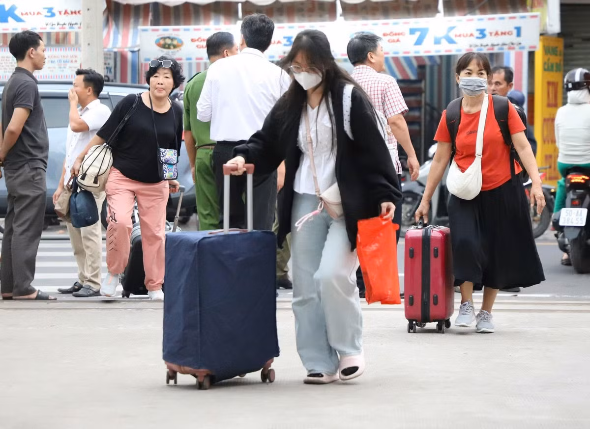 Những hành khách trong đợt trung chuyển bằng xe khách đầu tiên sau khi xuống xe đi vào ga Dĩ An để tiếp tục hành trình về ga Sài Gòn.