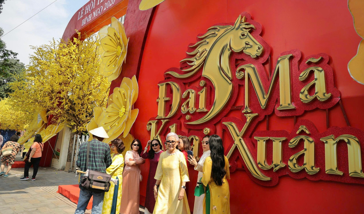 Du khách diện áo dài truyền thống, nhiều gia đình đưa con em đến tham quan, ghi lại những khoảnh khắc bên không gian trang trí rực rỡ sắc vàng của hoa mai, kết hợp cùng các tiểu cảnh mang đậm không khí Tết cổ truyền.