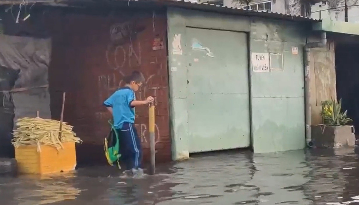 Học sinh bì bõm lội trên đường ngập nước trở về nhà