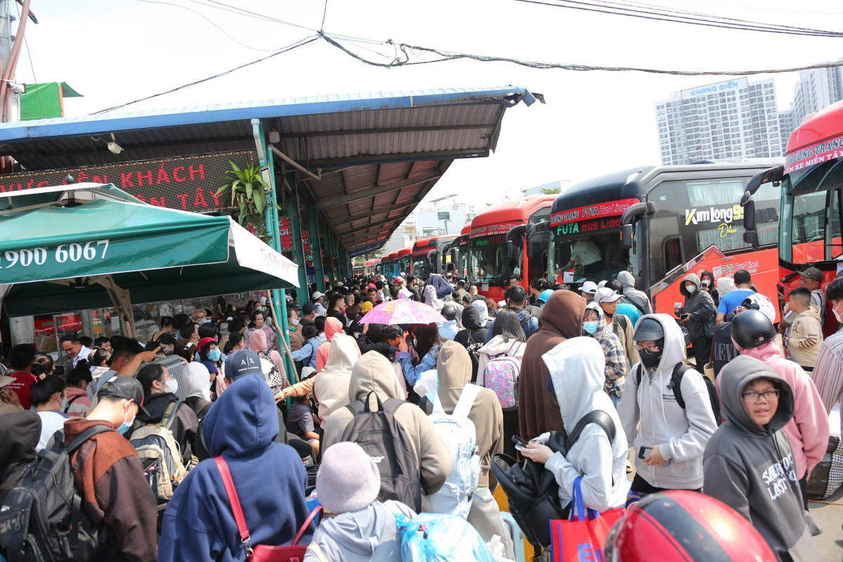 Hành lang lối đi BXMT ken đặc người về quê chiều 26 tháng Chạp. “Chờ đợi hơn 2 tiếng rồi mà chưa thấy xe để về quê, hỏi bảo vệ thì họ nói bị kẹt xe ở đâu đó nên xe về bến không kịp. Chặng đường về quê nghỉ Tết gian nan quá”, nam hành khách mệt mỏi nói.