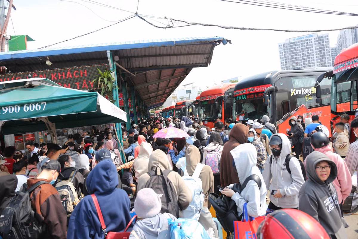 Hành lang lối đi BXMT ken đặc người về quê chiều 26 tháng Chạp. “Chờ đợi hơn 2 tiếng rồi mà chưa thấy xe để về quê, hỏi bảo vệ thì họ nói bị kẹt xe ở đâu đó nên xe về bến không kịp. Chặng đường về quê nghỉ Tết gian nan quá”, nam hành khách mệt mỏi nói.
