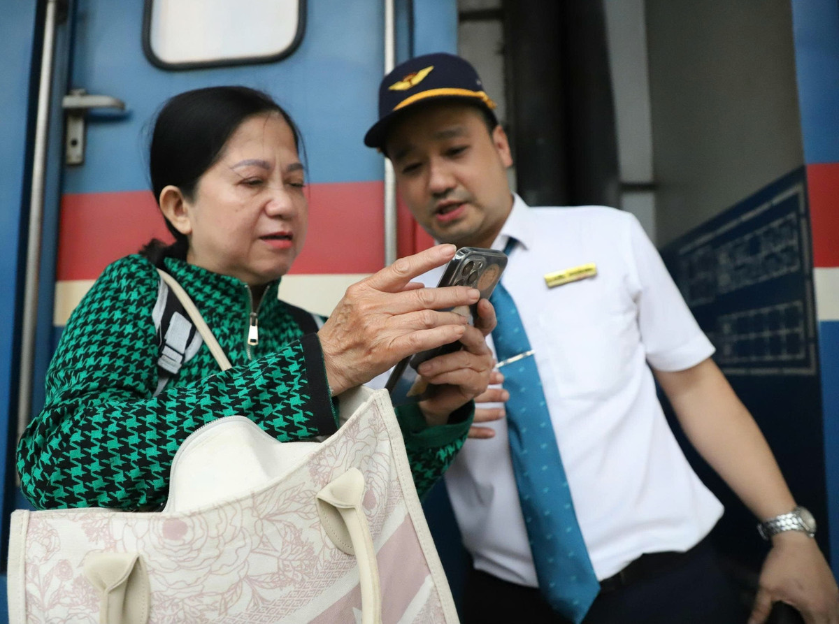 Nữ hành khách hỏi nhân viên ngành đường sắt vị trí toa tàu để thuận lợi di chuyển.