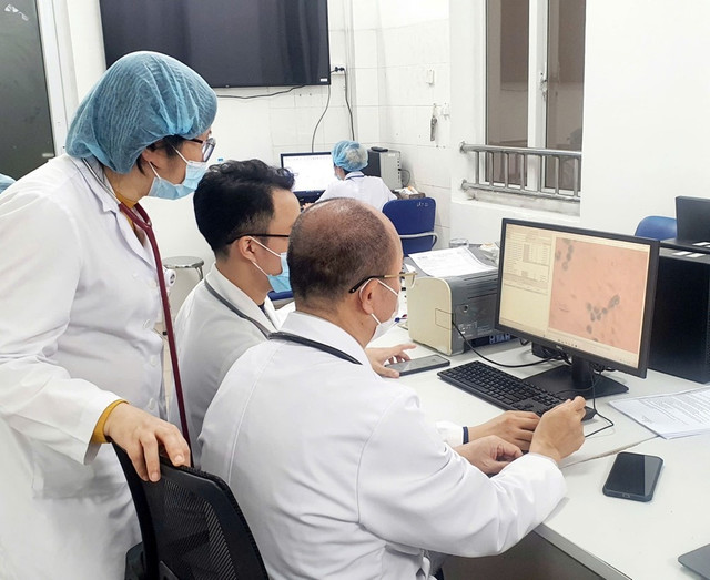 PGS.TS.BS. Đỗ Duy Cường cùng các bác sĩ Viện Y học Nhiệt đới xem kết quả soi dịch não tuỷ có chứa vi khuẩn não mô cầu là song cầu Gram âm - Ảnh BVCC nao-mo-1.jpg