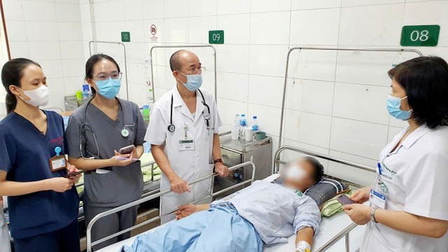 PGS.TS Đỗ Duy Cường, Viện trưởng Viện Y học Nhiệt đới Bạch Mai thăm khám cho bệnh nhân 38 tuổi trong chùm ca bệnh liên cầu khuẩn lợn do ăn tiết canh - Ảnh BVCC tiet-canh-hy.jpg