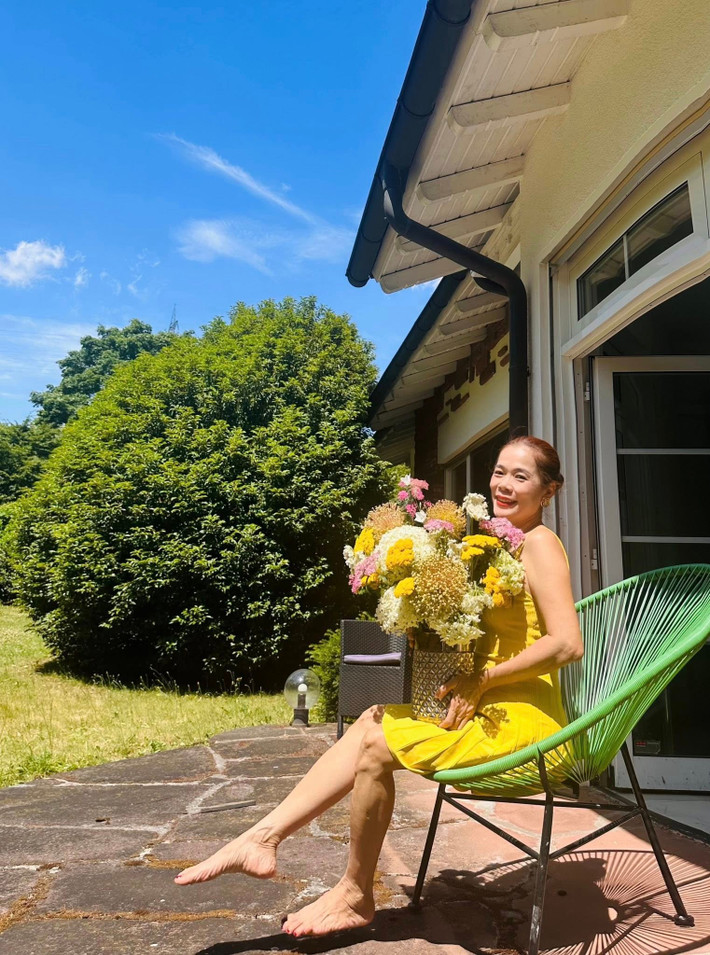 Ca sĩ Mỹ Lệ tạo dáng e ấp bên đóa hoa tỏi cảnh. Ảnh: FB Hoàng Thị Mỹ Lệ