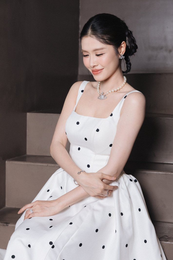 Trong loạt hình ảnh mới, cô chọn chiếc váy trắng chấm bi ôm dáng, khoe trọn đường cong mềm mại và làn da căng mịn.