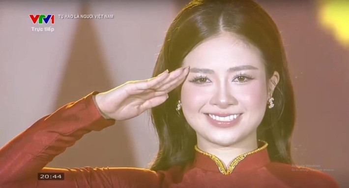 Nụ cười tươi cùng ánh mắt đầy tự hào của cô khi đứng dưới bóng cờ Tổ quốc đã tạo nên hình ảnh vừa trang nghiêm vừa đầy cảm xúc, lan tỏa niềm tự hào dân tộc đến người xem.
